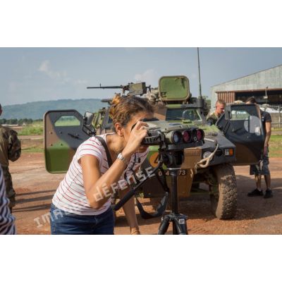 Une civile observe le terrain au moyen de jumelles infrarouges multifonction Sagem JIM LR 2, dans le cadre d'une présentation par les légionnaires du 2e REI du GTIA (groupement tactique interarmes) Centurion, lors d'une visite officielle sur le camp M'Poko de Bangui.