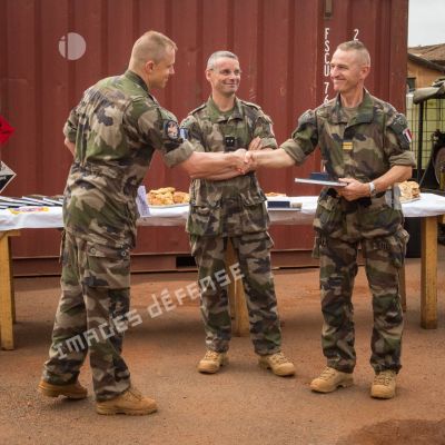 Remise d'ouvrages au colonel Walter Lalubin du 48e RTrs par le lieutenant-colonel Marc Bonnet du 61e RA, lors d'une réception à l'issue d'une cérémonie de transfert d'autorité du SGRM Raphael au camp M'Poko de Bangui, en présence du général de brigade Pierre Gillet, commandant la force Sangaris.