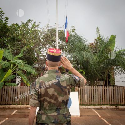 Le colonel Walter Lalubin salue les couleurs lors d'une cérémonie de transfert d'autorité du SGTRS Hermès au camp M'Poko de Bangui.
