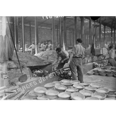 Plan général des fours de la boulangerie militaire autour desquels des boulangers s'affairent.