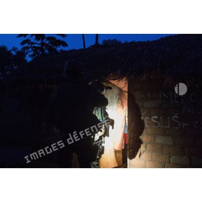 Fouille d'une habitation par un tirailleur du 1er RT du GTIA (groupement tactique interarmes) Vercors, lors d'une patrouille dans le village de Liby, dans le secteur de Damara, en appui aux casques bleus burundais de la MINUSCA (mission multidimensionnelle intégrée des Nations Unies pour la stabilisation en Centrafrique).