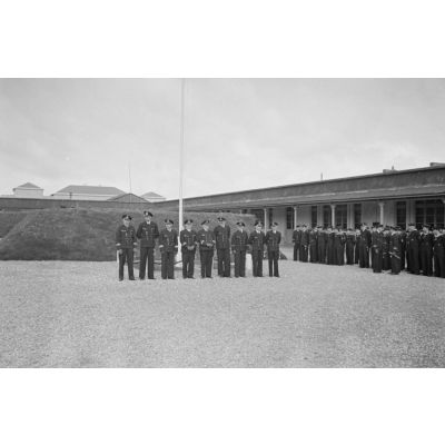 Lors d'une cérémonie de la Kriegsmarine à Saint-Nazaire, des sous-officiers au garde-à-vous devant le mat des couleurs.