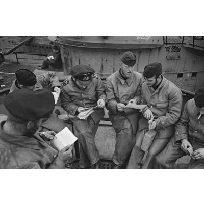 A Saint-Nazaire, à peine de retour de croisière, des sous-mariniers allemands parcourent la presse ou le courrier reçus pendant la mission.