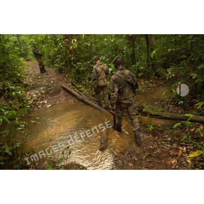 Des légionnaires du 3e régiment étranger d'infanterie (3e REI) franchissent un cours d'eau lors d'une patrouille à Ouanary, en Guyane française.