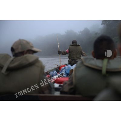 Des marsouins du 9e régiment d'infanterie de marine (9e RIMa) patrouillent à bord d'une pirogue dans la brume matinale de Maripasoula, en Guyane française.