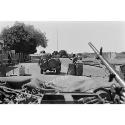 Les véhicules du 2e régiment étranger parachutiste (2e REP) et des journalistes passent un barrage routier tenu par des soldats zaïrois, aux abords du pont de Delcommune. <br>[Description en cours]