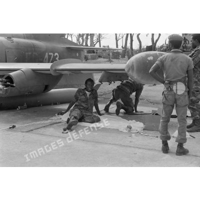 Des soldats zaïrois se reposent près des avions sur l'aéroport de Kolwezi. <br>[Description en cours]