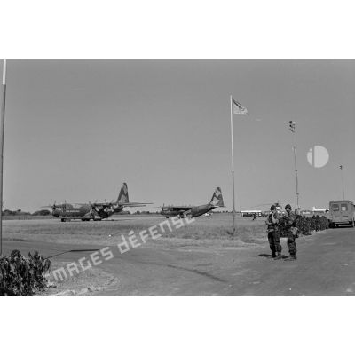 Atterrissage de deux avions de transport Hercules C130 de la force aérienne zaïroise sur l'aéroport de Lubumbashi. Au premier plan, deux soldats belges. <br>[Description en cours]