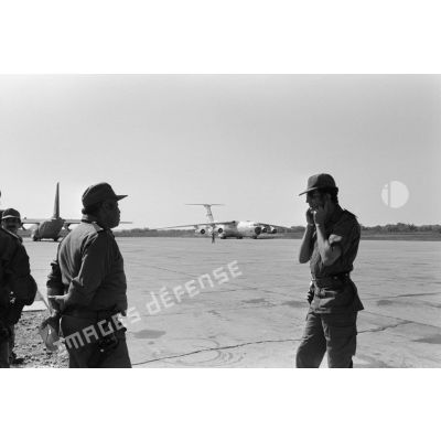 Arrivée du détachement marocain à bord d'un avion de transport américain Starlifter C141. Au premier plan à droite, le lieutenant Houttil de la gendarmerie royale marocaine. <br>[Description en cours]