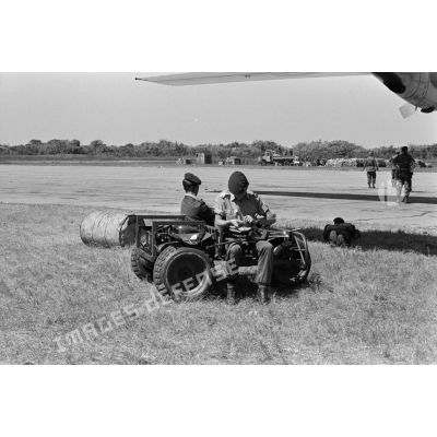 Deux soldats belges surveillent l'aire de parking de l’aérodrome de Lubumbashi assis dans leur véhicule léger aérotransportable. <br>[Description en cours]