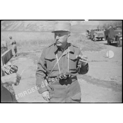 Portrait d'un capitaine mangeant en marge d'un convoi de blindés dans le Constantinois en mai 1945.