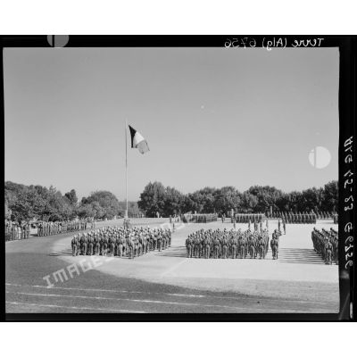 Le général de corps d'armée Henry Martin et le général de brigade Raymond Duval saluent les couleurs sur la place d'armes de Cherchell où les élèves sont regroupés.