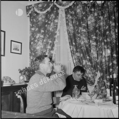 Des Européens d'Algérie prennent leur repas dans leur salle à manger.