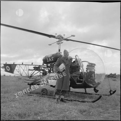 Portrait du général Daillier posant devant un hécoptère Bell 47G.