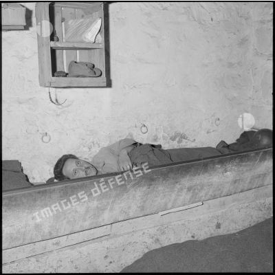 Un soldat s'installe dans la mangeoire de l'écurie de la ferme Grousset pour y dormir.