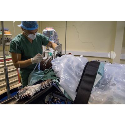Le médecin principal Jean-Vivien, médecin réanimateur, prépare un enfant pour son réveil au terme d'une opération de l'appendicite au pôle de santé unique (PSU) de N'Djamena, au Tchad.