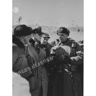 [Février 1951. Visite du général Mac Arthur au bataillon français. De gauche à droite : général Almond commandant le 10e CA, le général Mac Arthur, J.-M. Pelou, journaliste et le général B. Ridgway.]