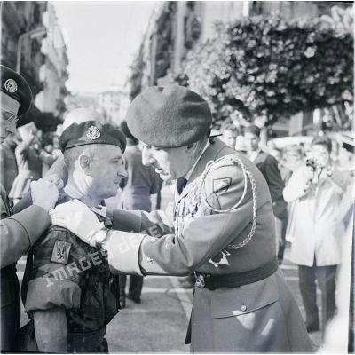 [Le général de division Jacques Massu remet la Légion d'honneur à un chef de bataillon (troupes de Marine) de la 10e division parachutiste en Algérie, 1960.]