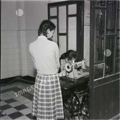 [Algérie, 1958-1962. Une jeune fille coud avec une machine à coudre de la marque Alfa.]