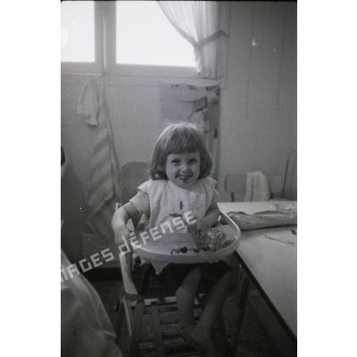 [Portrait d'une petite fille sur une chaise haute, s. d.]