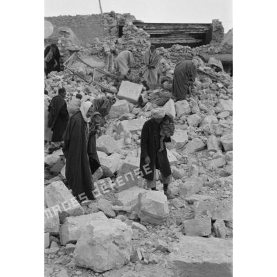 La population civile récupère des objets dans les ruines de la ville de Gafsa.