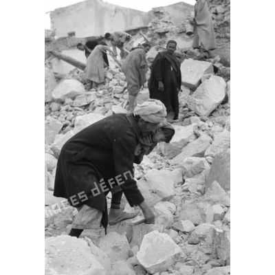 La population civile récupère des objets dans les ruines de la ville de Gafsa.