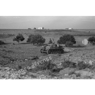 Un char Panzer II (Pz-II Ausf-C) de l'état-major d'un deuxième bataillon roule près d'un groupe d'habitation.