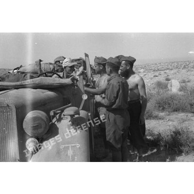 Des soldats allemands du Panzer.Artillerie Regiment 155 (Pz.Art.Rgt-155) installés dans une voiture Kfz-16 discutent avec des italiens du 24e RAA.