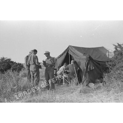 Un groupe de soldats et d'officiers allemands discutent près d'une tente.