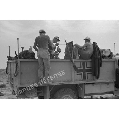 Des soldats de la 21e division blindée allemand (21.Panzer-Division, 21-Pz.Div.) s'installent à bord d'un camion Chevrolet WA de prise qui démarre.