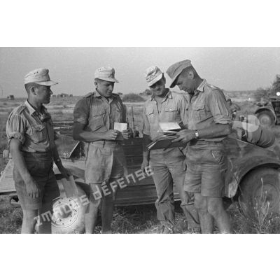 Un sous-officier distribue du courrier à trois de ses hommes devant une voiture Kübelwagen.