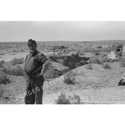 Un soldat italien pose devant une alvéole qui contient un canon de 75/27 M11.