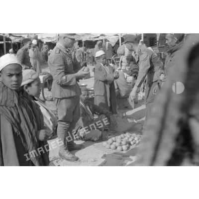 Deux soldats allemands dans un marché, on remarque la bande de bras Afrikakorps sur le bras droit du soldat de gauche.