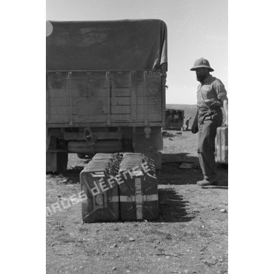 Un soldat dépose un jerrycan d'eau le long d'une rangée de nourrices et se fait ensuite servir de l'eau.