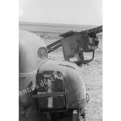 Des hommes du 155e Panzer Artillerie Regiment (Pz.Art.Rgt-155) cuisinent et changent une roue de leur véhicule tandis que des camions passent sur la route