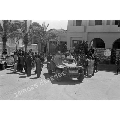 A Benghazi, un blindé SdKfz-222 et une voiture Kübelwagen au milieu de civils italiens.