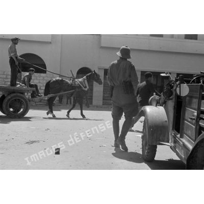 Une carriole tirée par une mule dans les rues de Benghazi, au premier plan une Kübelwagen allemande.