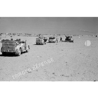 Des voitures Kfz-15, Kfz-21 et Kfz-3 qui composent l'état-major de Rommel près d'un camp et de canons italiens.