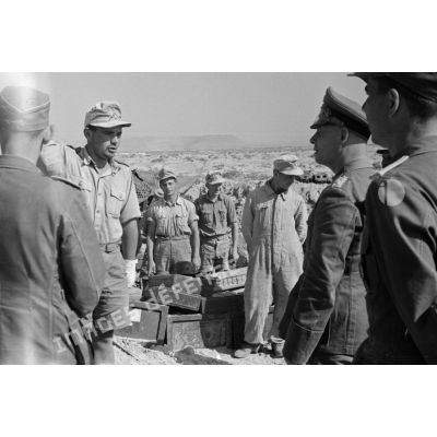 Le général Erwin Rommel près de l'encuvement d'une pièce de 8,8 cm FlaK, suit les explications d'un soldat ou d'un sous-officier.