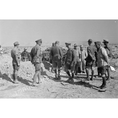Les généraux Rommel et Gause quittent l'encuvement d'un canon de 8,8 cm FlaK, entourés par un groupe d'officiers.