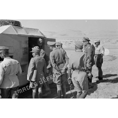 Les généraux Rommel et Gause entourés d'un groupe d'officiers près d'un véhicule.