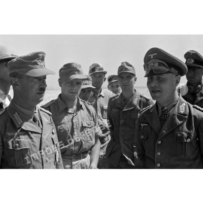 Le capitaine (Hauptmann) Wilhelm Bacht et le général (Generalleutnant) Erwin Rommel entourés d'officiers et de soldats.