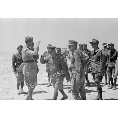 Le général Erwin Rommel suivi par des officiers de son état-major salue un officier italien qui l'accueille.