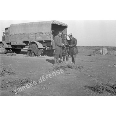 Trois officiers en discussion, près d'un camion Lancia 3-R-0 du 133e Regiment Carristi.