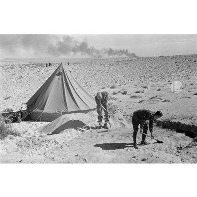 Deux soldats creusent près d'une tente.
