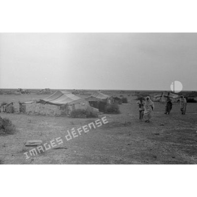 Un campement de Bédouins dans le désert, en arrière-plan une colonne allemande.