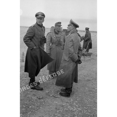 Lors de la mise en batterie du canon italien, le général Erwin Rommel et le colonel (Oberstleutnant) Westphal discutent devant un officier de la Luftwaffe.