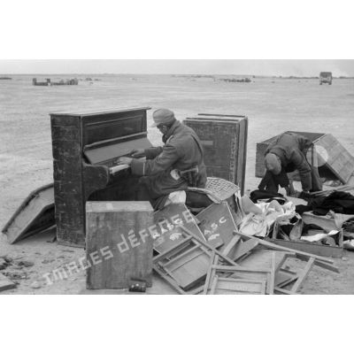 Un soldat allemand joue du piano au milieu de débris.