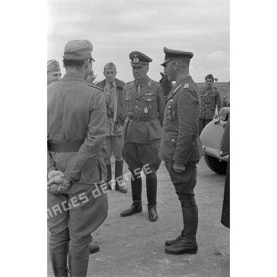 Le général (Generalmajor) Alfred Gause salue le général Ettore Bastico, en compagnie du général (General der Panzertruppe) Ludwig Crüwell.