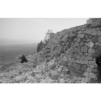 Au fort de Mechili, des soldats italiens reconstruisent un mur éboulé.